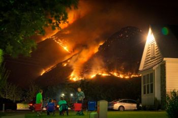 Tourism Fire A family watches a nearby wildfire from their front lawn