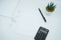 Budget A financial and money themed photo featuring a blank paper on a desk next to a pen and calculator. Crunch the numbers! 