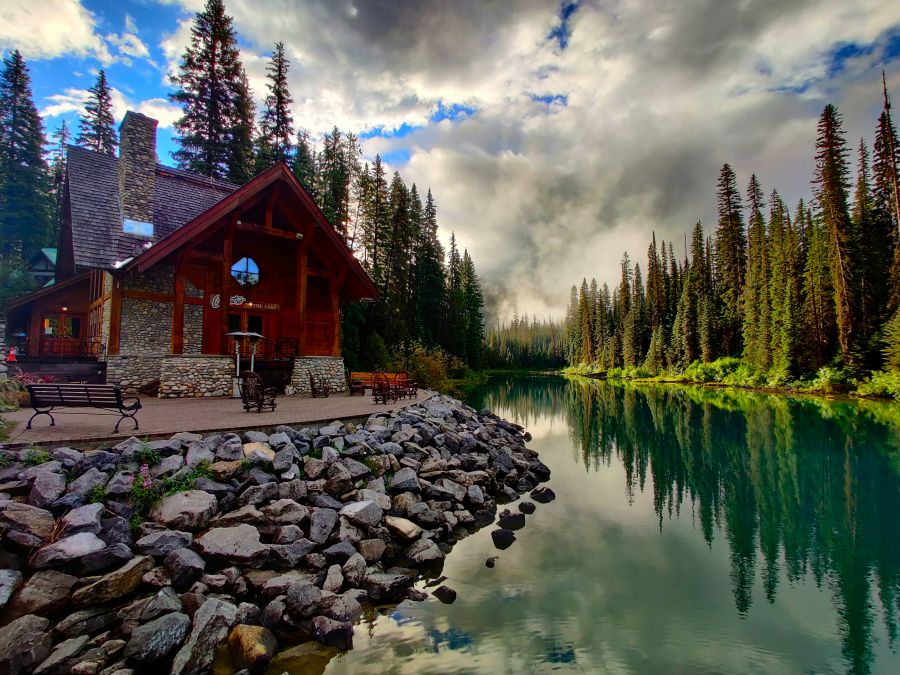 Lodge Sunrise on a rainy day over a greenish blue lake and a lodge.