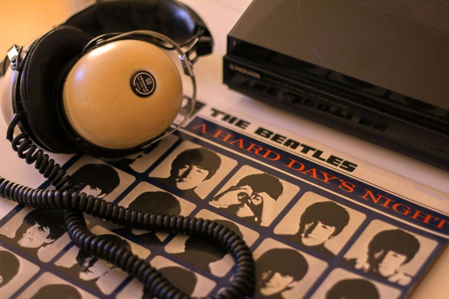 Fugue Beatles Retro Reverie – A 1970s Hi-Fi Headphone & Beatles Vinyl Still Life A vintage 1970s hi-fi headphone rests gracefully on a turntable, its padded ear cups and coiled cord whispering of analog warmth. Beside it, a weathered Beatles LP leans against the player. The golden morning light catches the dust motes hovering above the scene, as if time itself paused to listen. A love letter to tactile music, crackling imperfections, and the ritual of dropping the needle. 