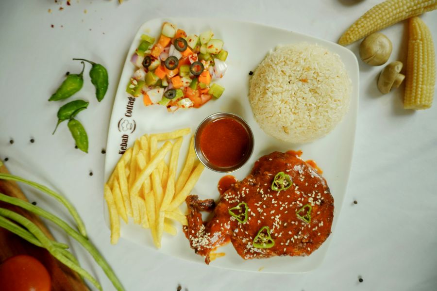 Firefighters meal A vibrant platter featuring glazed chicken, golden fries, rice, and fresh salad, beautifully captured 