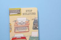 Bullying Stop bullying, anti-bullying, stop cyberbullying. Typewriter notebook on blue background kindness matters,be kind,stop cyber bullying
