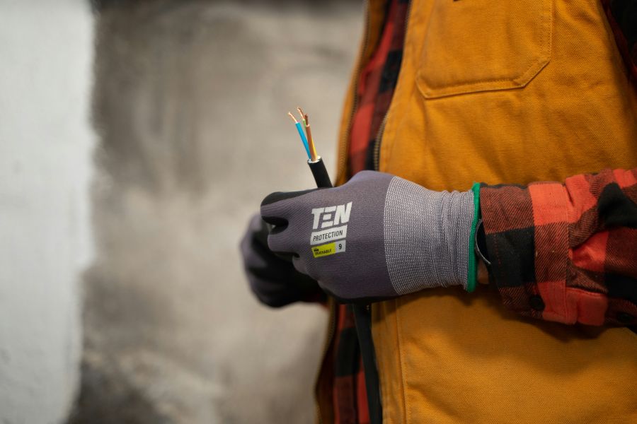 Electrician An electrician with work gloves holding a wire. 