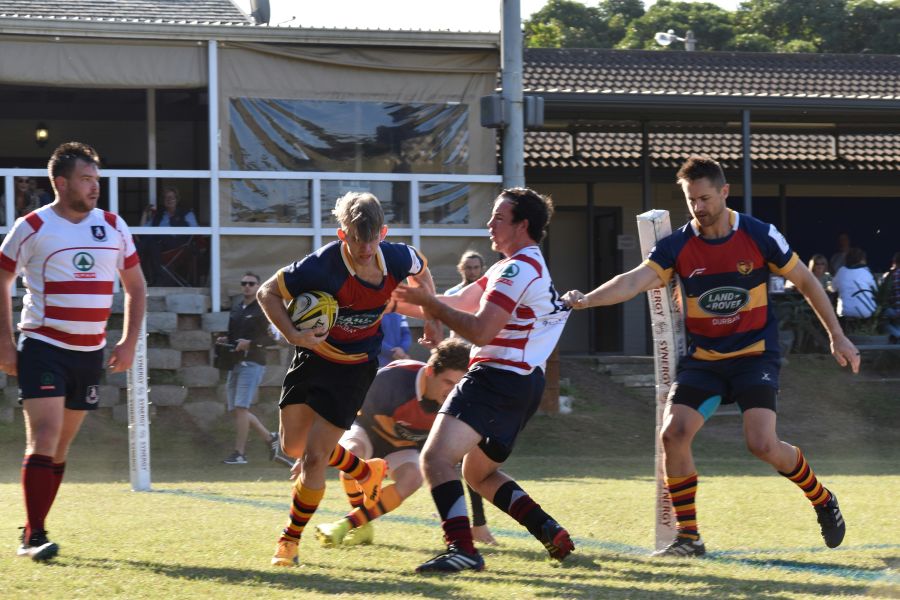 Rugby match Group of young men playing rugby in South Africa, holding a rugby ball, sunny afternoon, in club colours.  rugby pitch,drag,pull