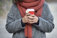 Cote d Person holding to-go coffee scarf,coffee,shawl