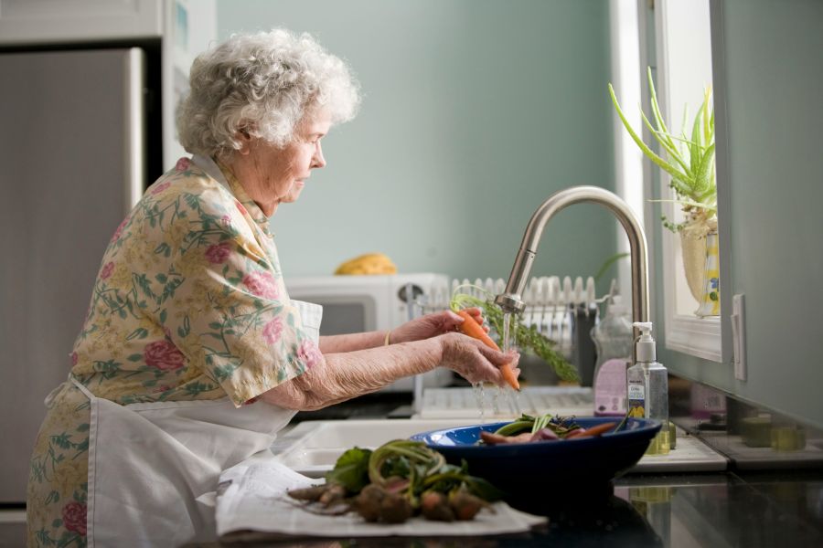 Grandmother Elderly woman cleaning vegetables. Photo by Cade Martin 