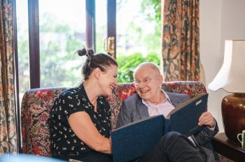 Care home Woman reading to older man