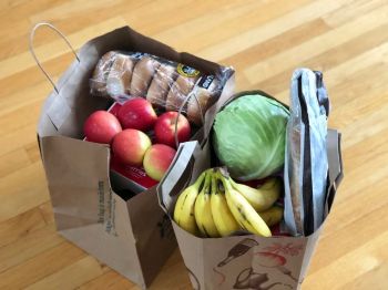 food donation Paper bags with groceries including fruits and vegetables and bread
