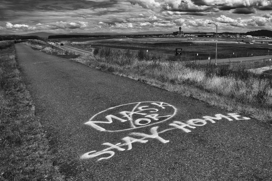 Controversy dissension Mask or Stay Home spray painted on walkway, black and white photo. grey,portland,or