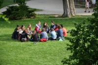Dialogue A group of young people sitting on the grass in a park in a circle facing each other. 