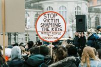 School violence Sign showing STOP VICTIM SHAMING THE KIDS; PROTECT PEOPLE NOT CORPORATIONS  on a Fridays For Future demonstration in Berlin, January 2019  