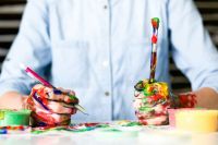 Creativity Man holds painted mess painting,workshops,optimistic