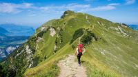 nature hike woman with baby on her back hiking an adventerous path on top of a mountain 