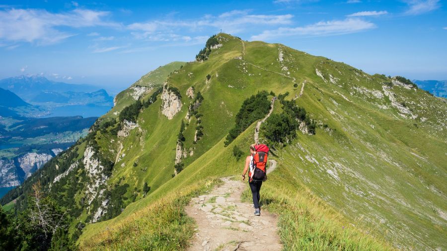 nature hike woman with baby on her back hiking an adventerous path on top of a mountain 
