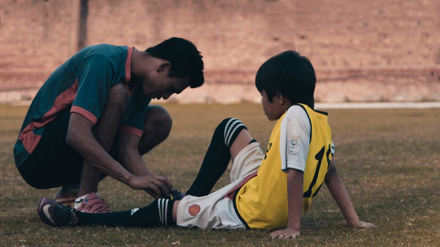 Injury ou 2-men-in-red-and-white-jersey-shirt-sitting-on-grass-field- injury,football,training