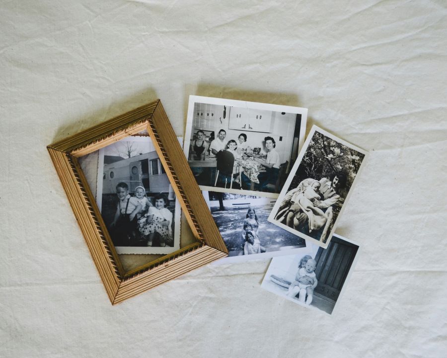 Memory family Overhead view of old black and white family photos with overlapping wood frame. 