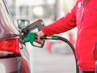Fuel theft Closeup of man pumping gasoline fuel in car at gas station 