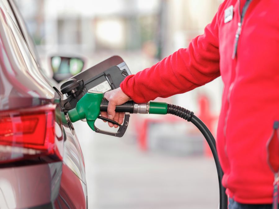 Fuel theft Closeup of man pumping gasoline fuel in car at gas station 