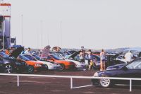 Car gathering people at car show 