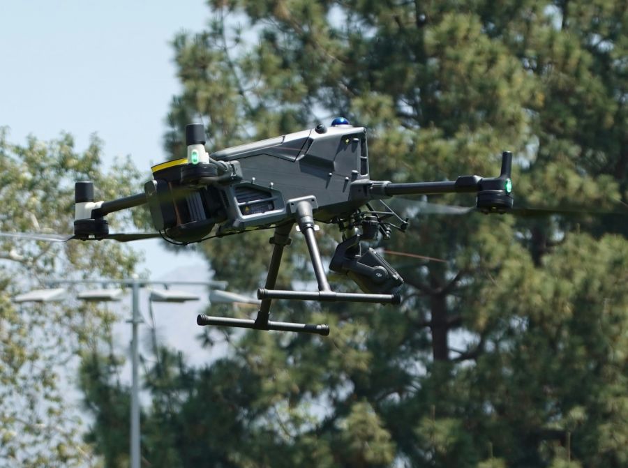 prison drone An industrial drone carrying an drone parachute recovery system flying over an park. 