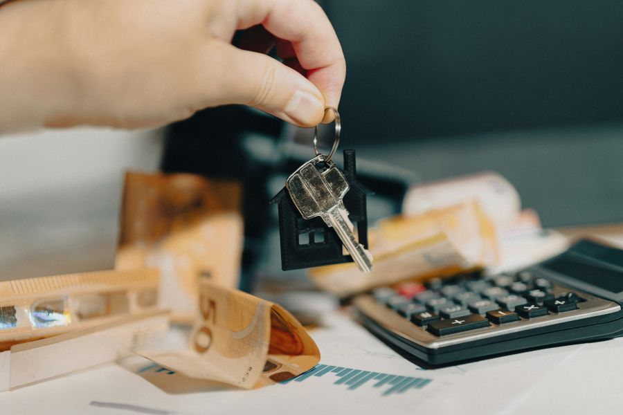 Rental market hand holding door keys real estate market home finance calculator documents analytics charts 