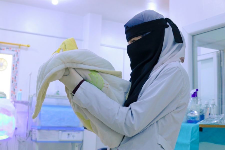 neonatology A nurse wearing a niqab holds a newly born baby in the incubator ward 