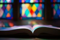 Teenagers Burns An open Bible in front of a large wall of stained glass windows inside of an old church. montgomery bell state park,tn,jackson hill road