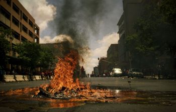fire protest During 2016 South Africa experienced many protests. Most of them were around tertiary education fees. In November 2016, the Economic Freedom Fighters (EFF) party of South Africa took to the streets of Pretoria.
It was mostly calm as the EFF had several marshals walking with the various clusters. Despite the massive police presence, there were a handful of vandals and pyromaniacs around.
I also got pelted with a few stones in the process.