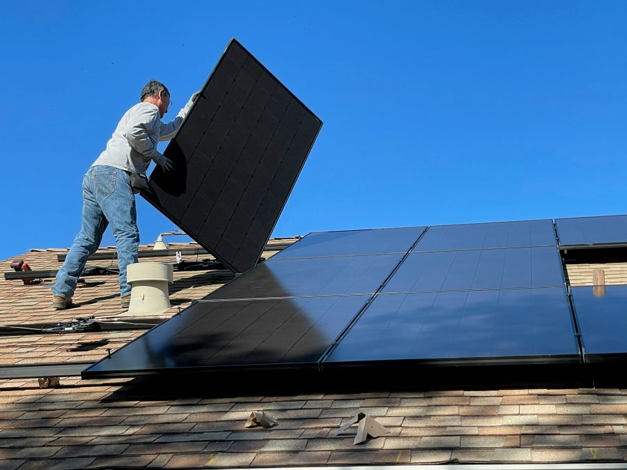 solar panels Worker installing solar panels on a roof 