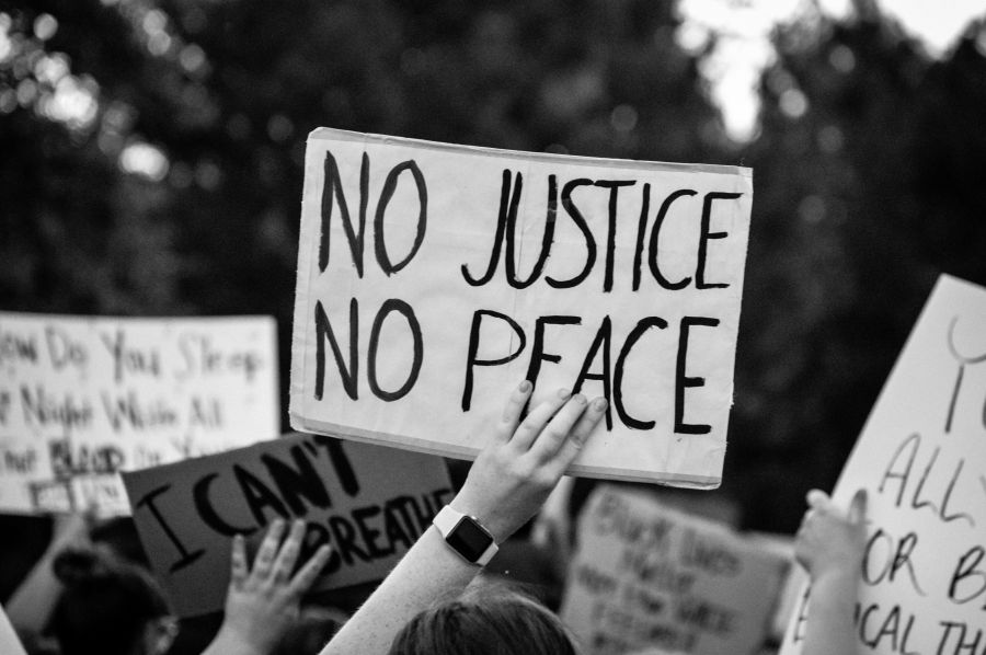 Protesters a peaceful black lives matter protest, holding a sign that says 