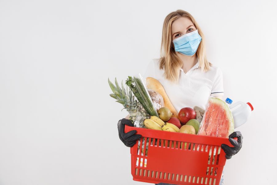 Shopping basket Young woman with goods in basket. The girl made a purchase. Girl holding a basket of groceries. Vegetables
 fresh food,face mask,grocery basket