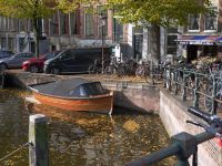 Weather Sunny Amsterdam Fall with tree leaves in the reflecting canal water, free street photography from Holland - Autumn started in this picture, also in the old canals of the city. The leaves are becoming yellow and fall... This is a corner of the canal street Herengracht, crossing the shopping street Utrechts straat at the right. The historical brick walls of many canals in the city have become very vulnerable and must be renovated in coming years. Free pic photo of canals in Amsterdam city The Netherland amsterdam,urban nature,netherlands: street utrechtsestraat