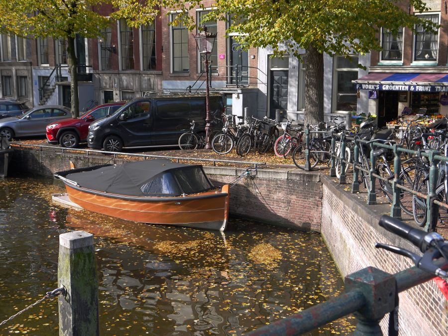 Weather sunny Amsterdam Fall with tree leaves in the reflecting canal water, free street photography from Holland - Autumn started in this picture, also in the old canals of the city. The leaves are becoming yellow and fall... This is a corner of the canal street Herengracht, crossing the shopping street Utrechts straat at the right. The historical brick walls of many canals in the city have become very vulnerable and must be renovated in coming years. Free pic photo of canals in Amsterdam city The Netherland amsterdam,urban nature,netherlands: street utrechtsestraat