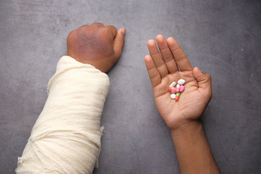 Fracture injured painful hand with bandage and medical pills on hand  arthritis,bandaged,bandage