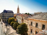 heritage Montpellier View over the historic center of Montpellier, with elegant Haussmann-style buildings and the spire of Saint-Anne Church rising above the rooftops. 