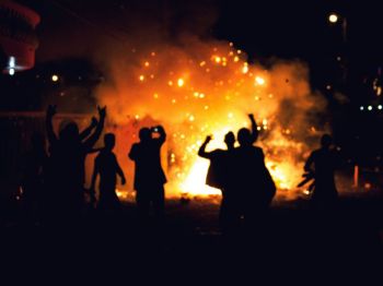 protest violence People gathering near a bonfire at night.  