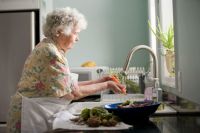 Elderly people Elderly woman cleaning vegetables. Photo by Cade Martin 