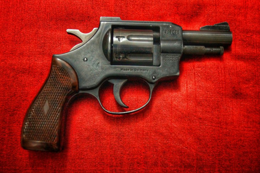 Gun violence a vintage revolver with a red backdrop 