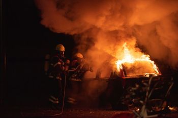 firefighters strike Two firefighters fighting a heavy car fire with water
