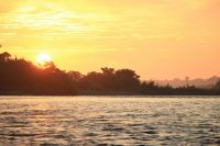 Nature Amazon Embrace the serene beauty of dawn with this captivating sunrise over the Rio de Madre de Dios, captured in the heart of the Manu National Park. The early morning sun spills its golden light across the sky, painting a breathtaking canvas of warm hues that reflect on the tranquil waters. As the new day begins in this biodiverse sanctuary, the image evokes a sense of peace and the timeless allure of nature's daily masterpiece. 