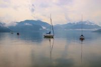 Peaceful vacation Lake Attersee in Upper Austria, Salzkammergut, Europe. Small sailing boats in the morning fog. The mountain range around is named 