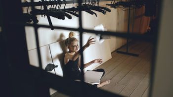 Teenage struggle Young teenage girl dancer crying and tearing book sits on floor in hall
