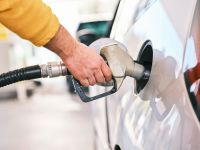 Fuel Pumping gas at gas pump. Closeup of man pumping gasoline fuel in car at gas station. 