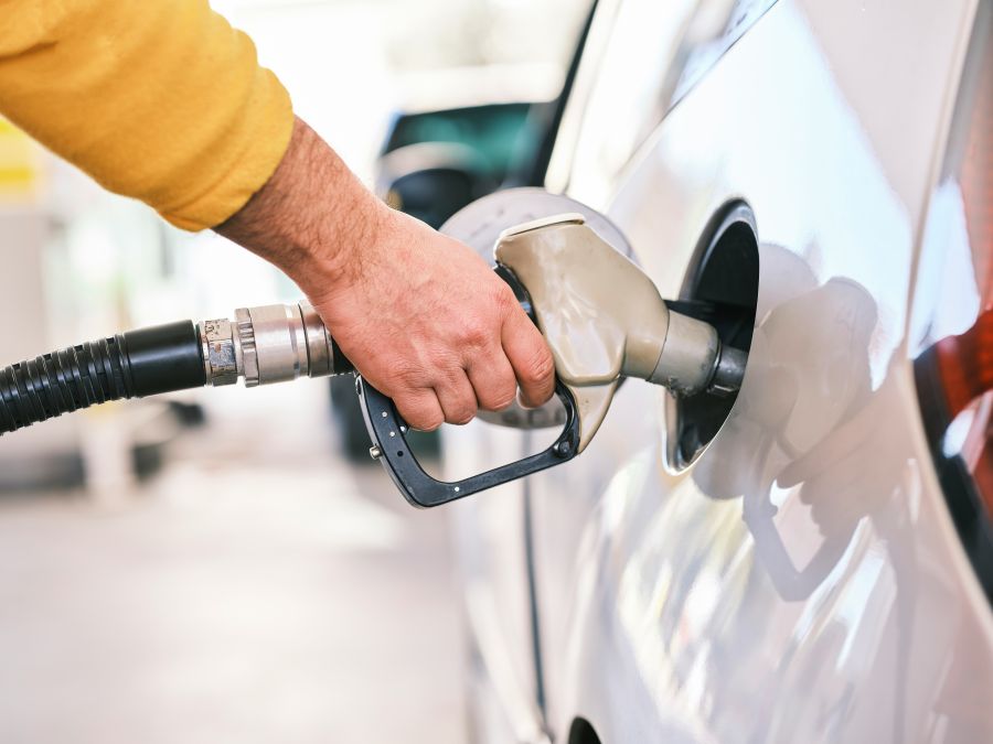 Fuel Pumping gas at gas pump. Closeup of man pumping gasoline fuel in car at gas station. 