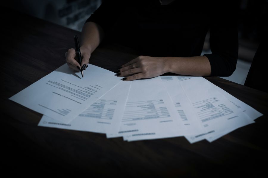 taxes A lady signing a contract with a ballpoint pen. 