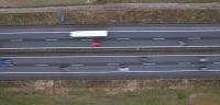 Road safety Captured from above, this image portrays the dynamic flow of traffic on a highway. Vehicles blur into streaks of color, illustrating the pace of life on the road. The patterns of the lanes and the sense of movement offer a glimpse into daily commutes and the arteries of transportation. 