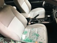 Car theft the aftermath of a car break-in, with shattered glass scattered across the passenger seat. The side window has been broken during a theft. 