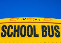 school scandal lettering saying school bus on the front of a yellow bus 