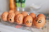 Emotions Creative background with chicken eggs in the kitchen close-up. Trendy eggs with faces painted on their shells. Emotional faces on eggs - festive background, design for website about psychology and business emotions,painted faces,faces