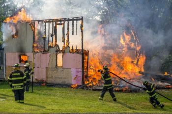 fire damage Firefighters practicing in a controlled burn on an old home